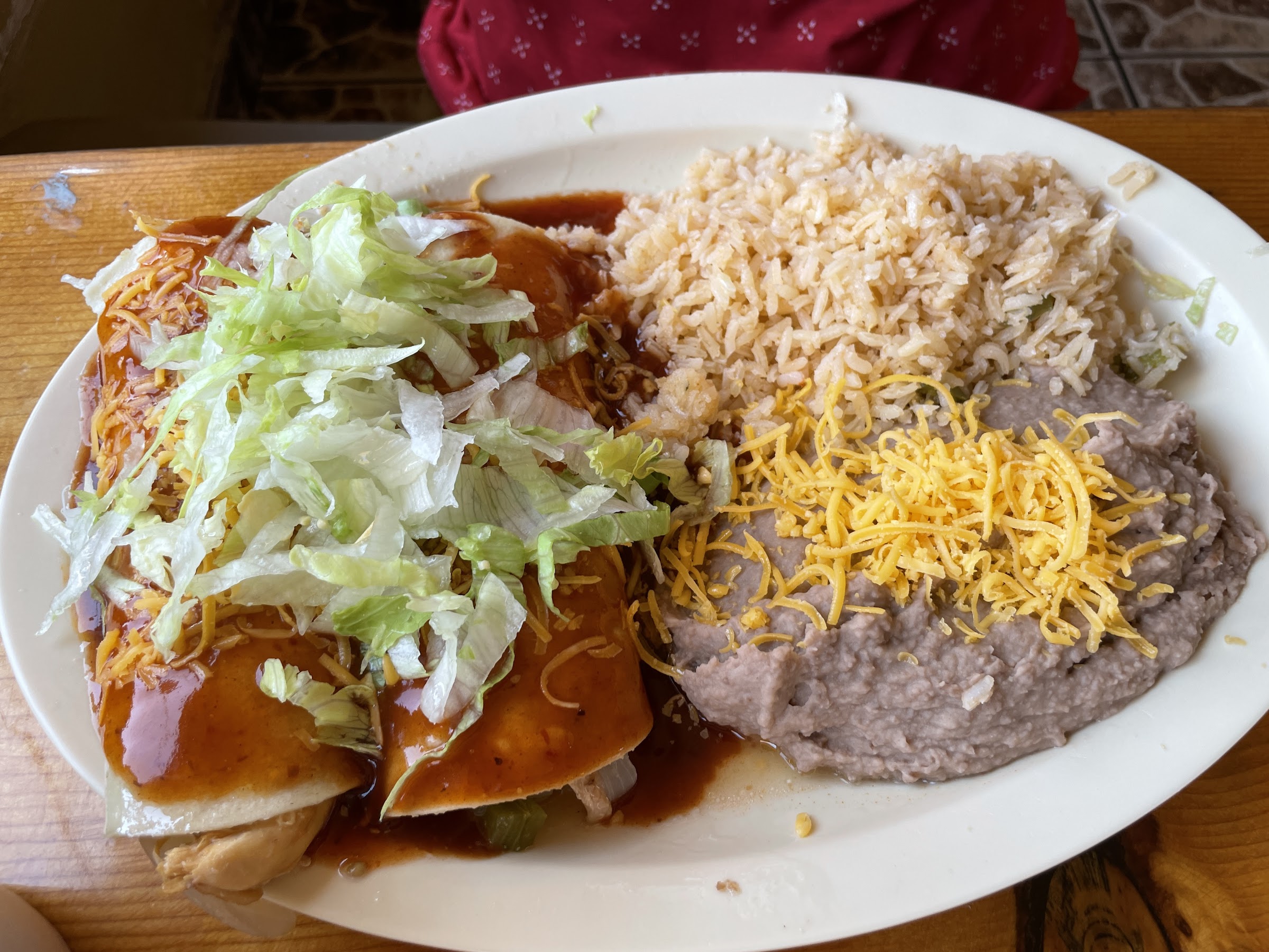 Enchilada plate with Mexican rice and refried beans topped with cheese at Wild West Cowboy Steakhouse.